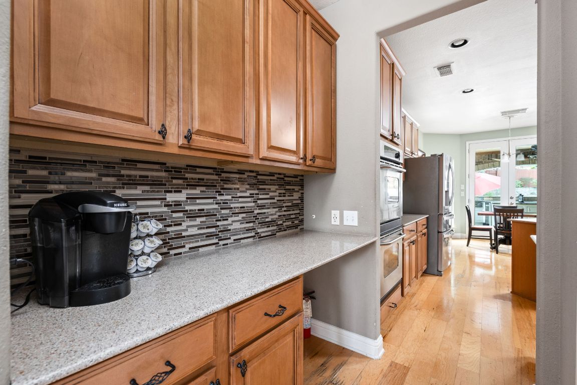7109 Via Correto Drive Austin, TX 78749 - Photo 12 of 40 a kitchen with stainless steel appliances granite countertop a sink a stove and a wooden floors