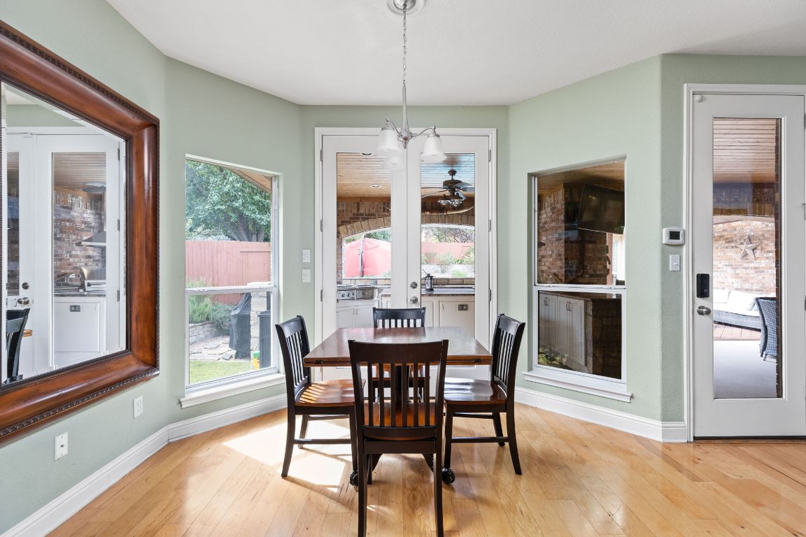 7109 Via Correto Drive Austin, TX 78749 - Photo 13 of 40 a dining room with furniture large windows and a chandelier