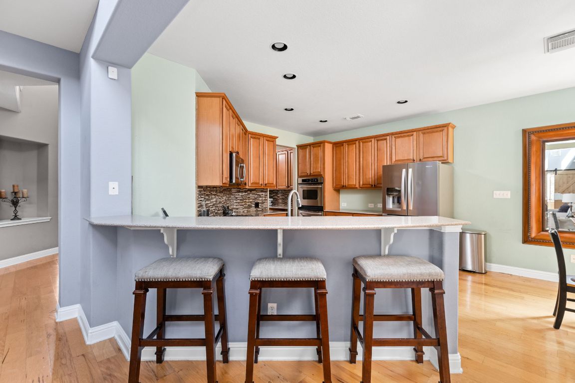 7109 Via Correto Drive Austin, TX 78749 - Photo 9 of 40 a kitchen with stainless steel appliances a dining table chairs microwave and sink