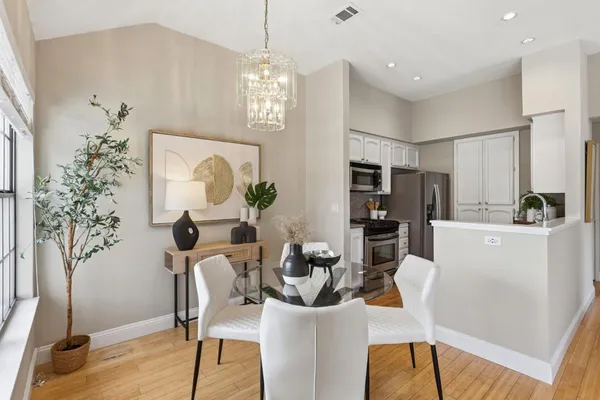 a view of a dining room with furniture a chandelier and wooden floor