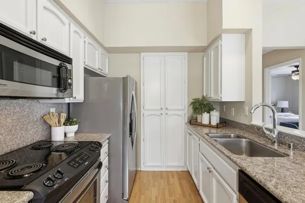 a kitchen with stainless steel appliances granite countertop a sink stove and refrigerator
