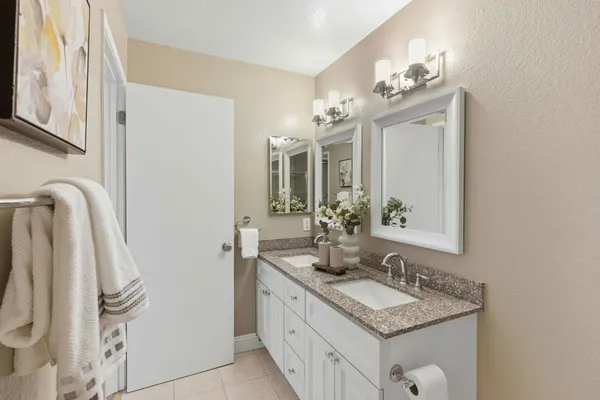 a bathroom with a granite countertop sink a mirror and a shower