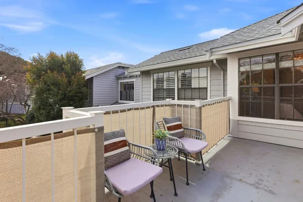 a view of a patio with table and chairs with wooden floor and fence
