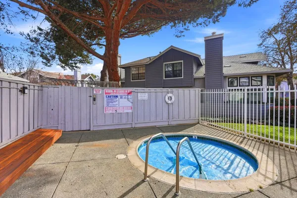 a view of a backyard with a tub and wooden fence