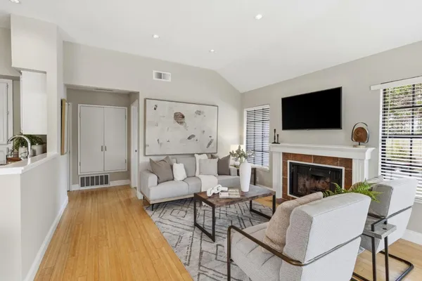 a living room with furniture a flat screen tv and a fireplace