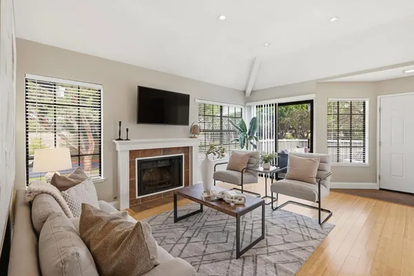 a living room with furniture a flat screen tv and a fireplace