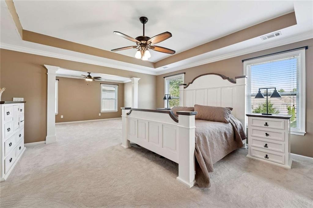 4510 Trailmaster Circle Cumming, GA 30028 - Photo 24 of 49 a bedroom with a large bed and a chandelier