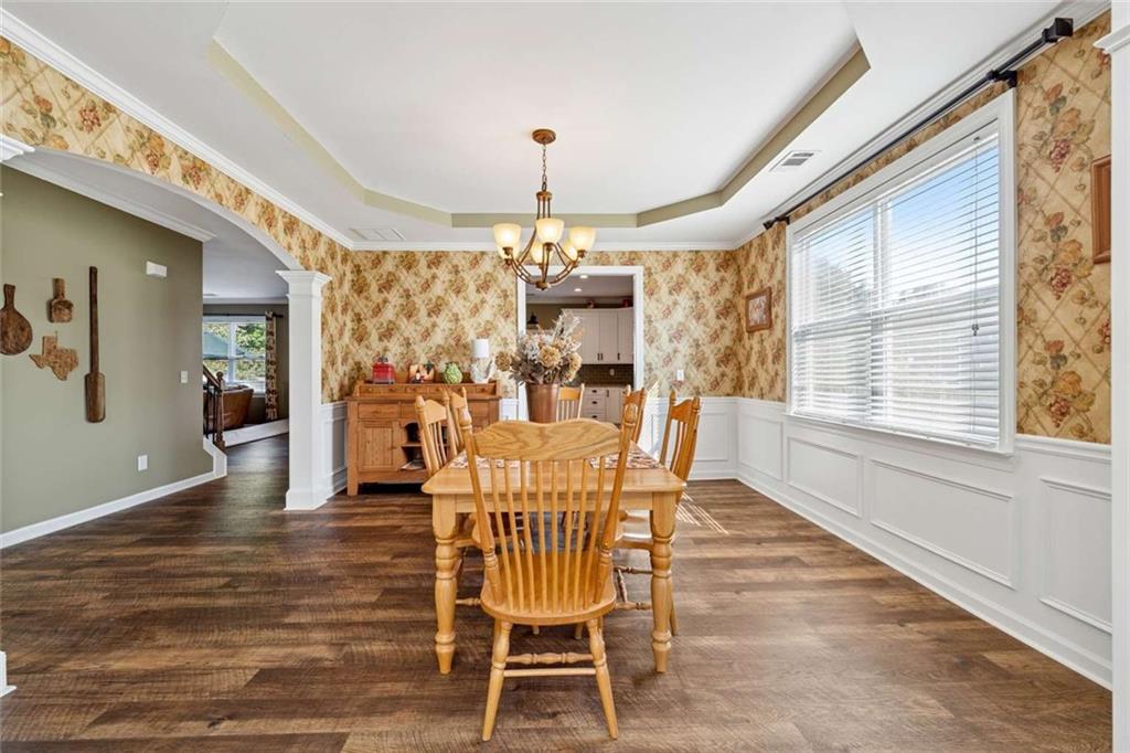 4510 Trailmaster Circle Cumming, GA 30028 - Photo 5 of 49 a dining room with furniture a chandelier and wooden floor