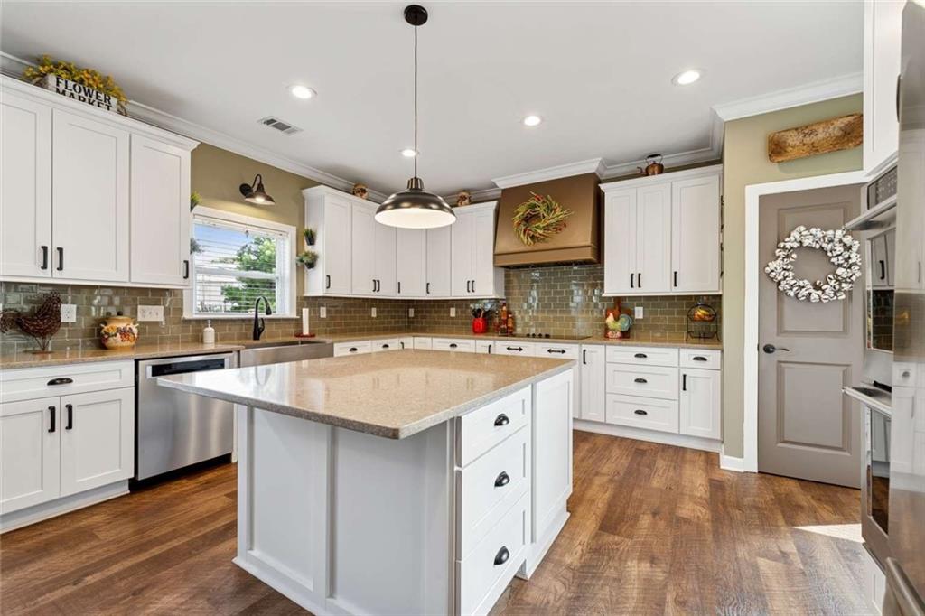 4510 Trailmaster Circle Cumming, GA 30028 - Photo 10 of 49 a kitchen with stainless steel appliances granite countertop a refrigerator a sink dishwasher a stove and white cabinets with wooden floor