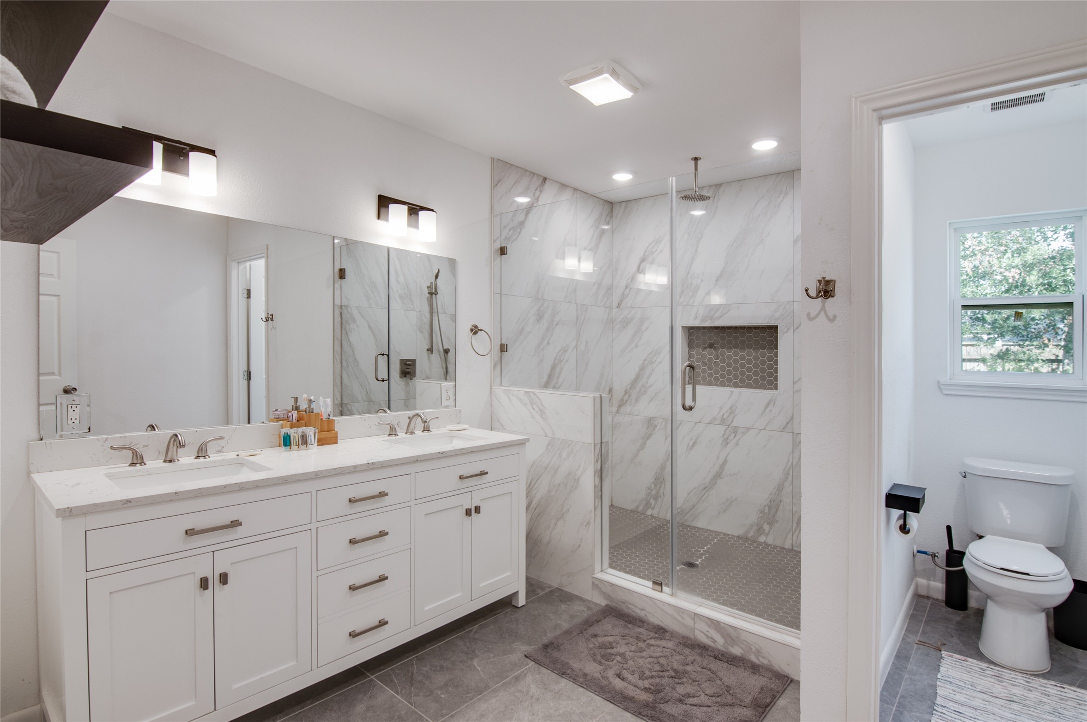 8922 Opelika Street Houston, TX 77080 - Photo 14 of 23 a bathroom with a double vanity sink toilet and shower