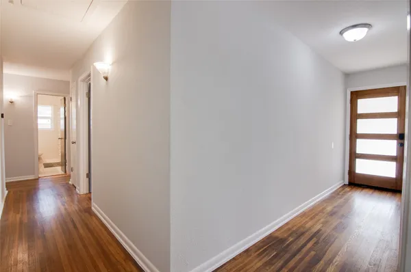 a view of a room with wooden floor and a window