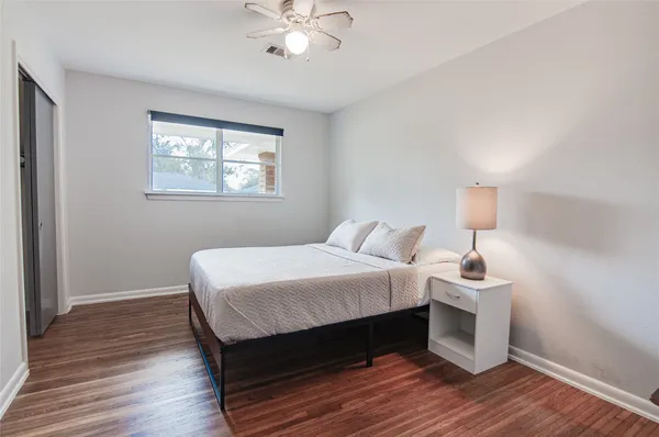 a bedroom with a bed and wooden floor