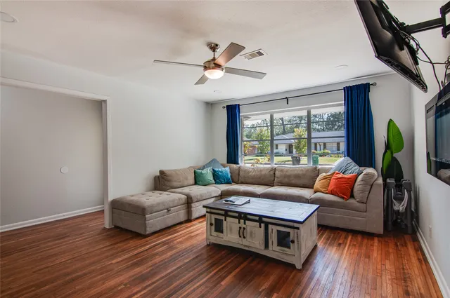 a living room with furniture and wooden floor