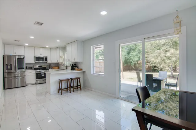 a open kitchen with cabinets table and chairs