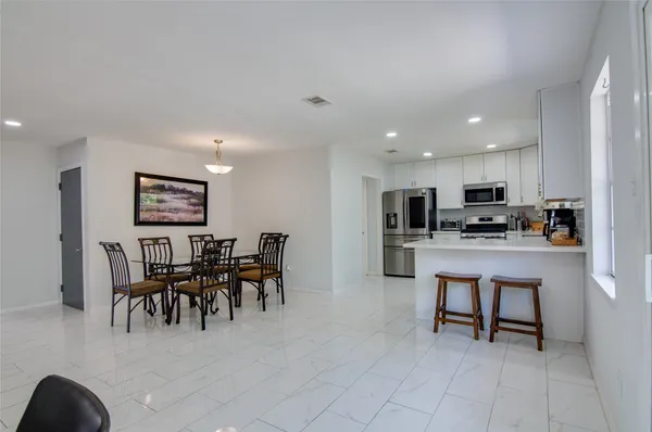 a open kitchen with cabinets table and chairs