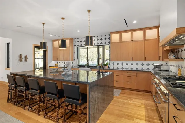 a large kitchen with a large window and stainless steel appliances