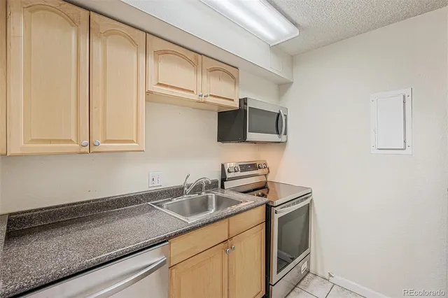 a kitchen with stainless steel appliances granite countertop a sink a stove and microwave