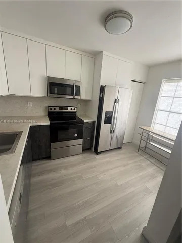 a kitchen with stainless steel appliances a stove sink and a refrigerator