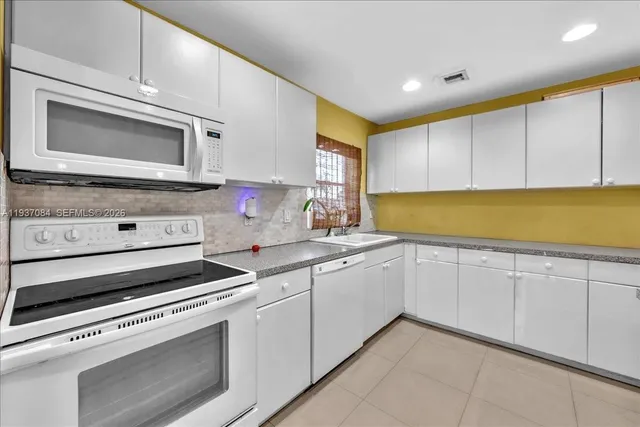a kitchen with granite countertop cabinets stainless steel appliances and a sink