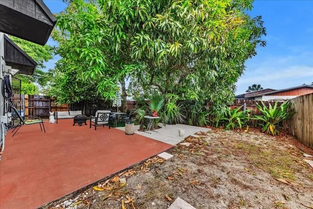 a patio with table and chairs and potted plants