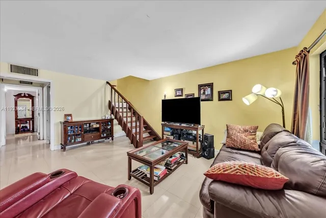 a living room with furniture a flat screen tv and a couch