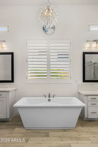 a bath room with a sink mirror and a bath tub