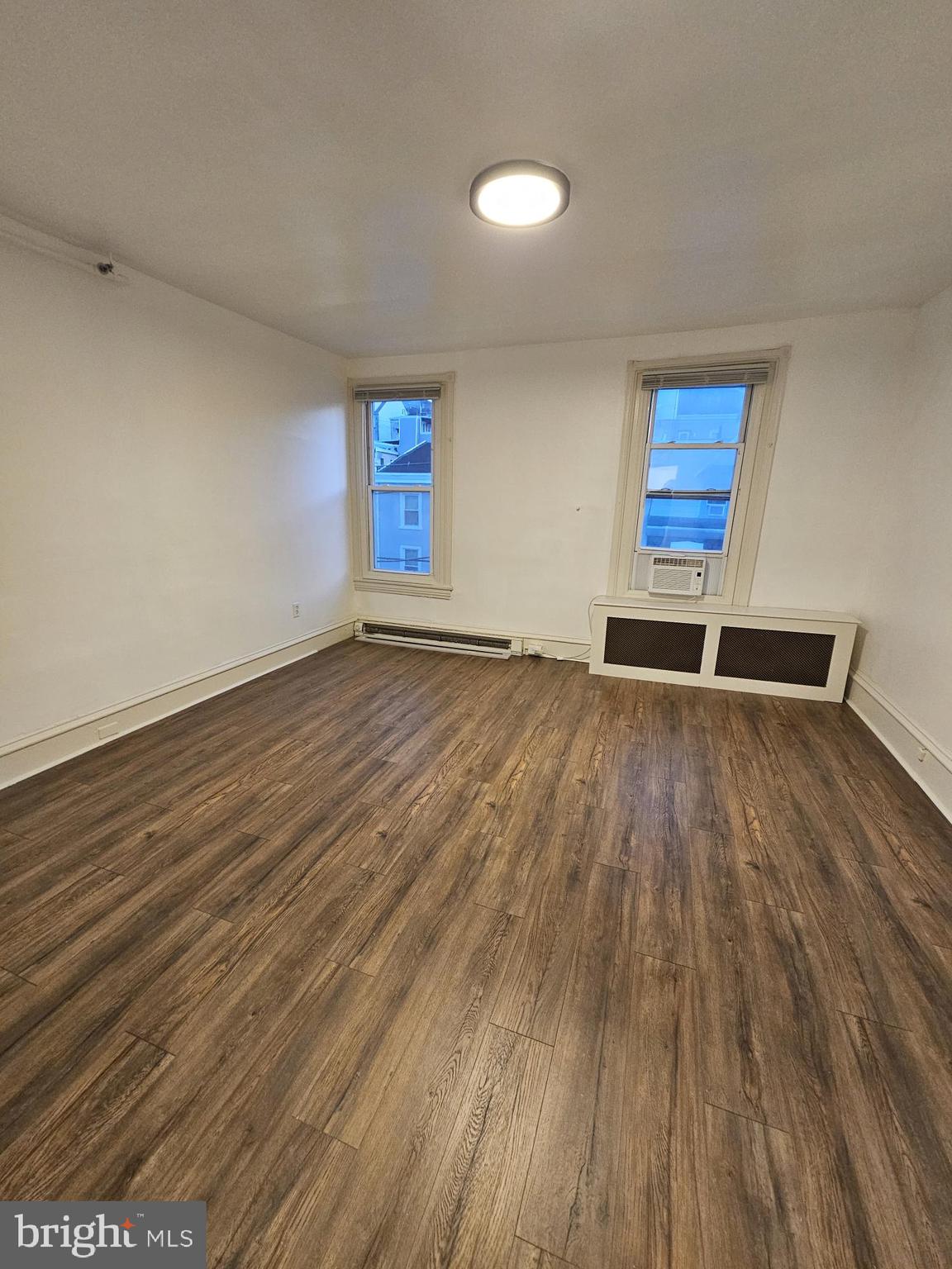 3922 Terrace Street, Unit 3 Philadelphia, PA 19128 - Photo 4 of 10 a view of an empty room with wooden floor and a window