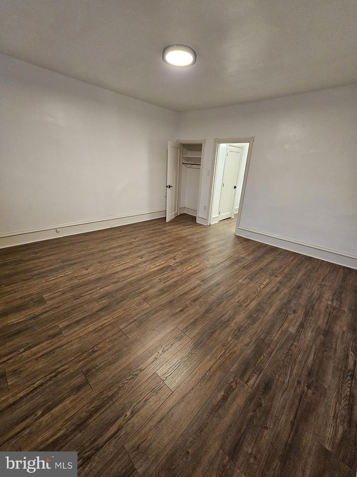 3922 Terrace Street, Unit 3 Philadelphia, PA 19128 - Photo 5 of 10 an empty room with wooden floor and windows