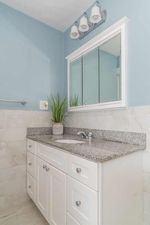79 Mill Street Natick, MA 01760 - Photo 11 of 21 a bathroom with a granite countertop sink and a mirror