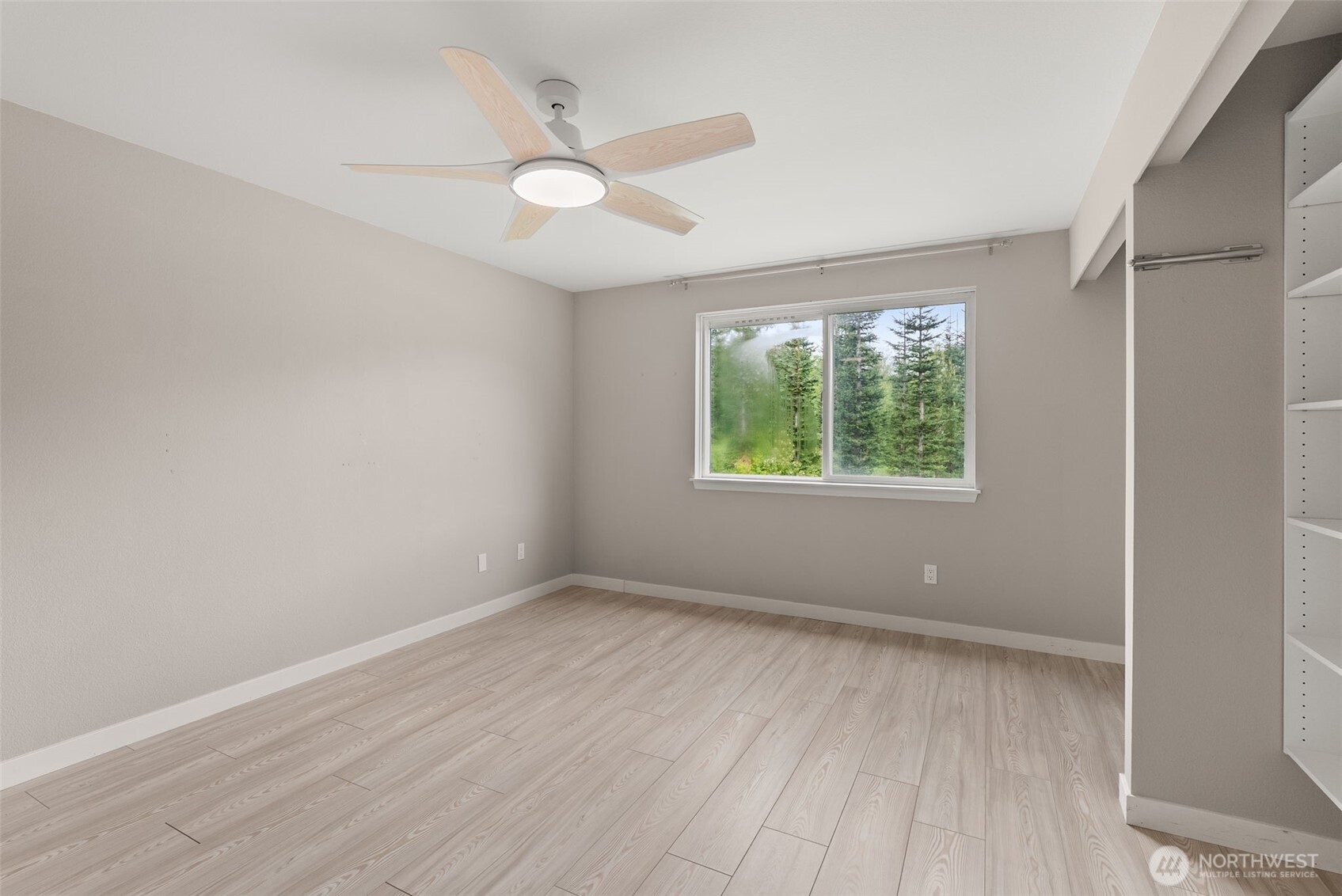 269 Elk Creek Road Raymond, WA 98577 - Photo 11 of 38 an empty room with wooden floor and windows