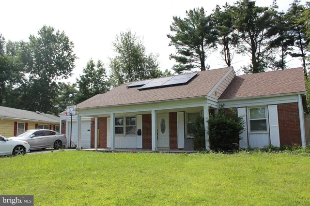 a view of a white house with a large windows and large trees