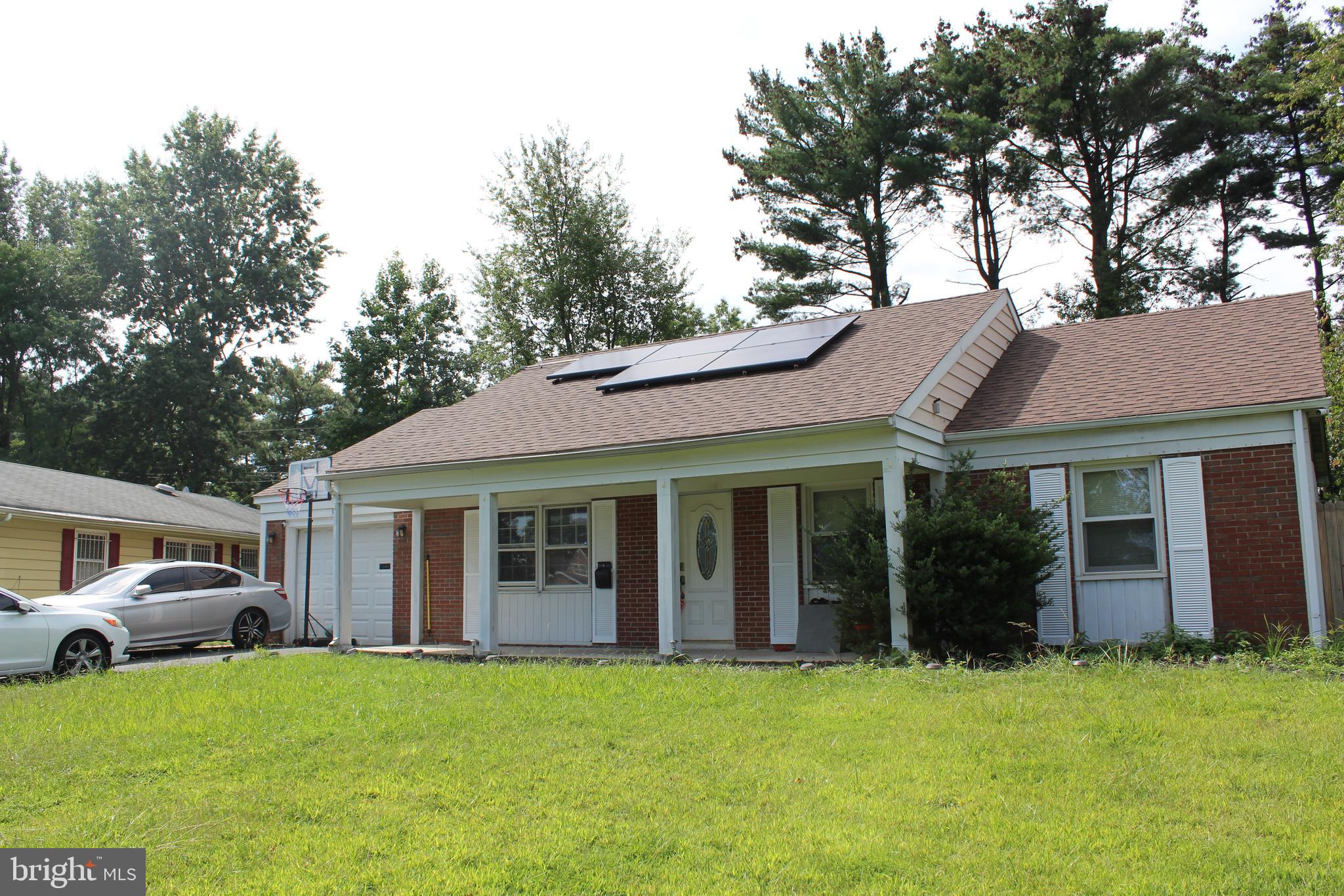 a view of a white house with a large windows and large trees