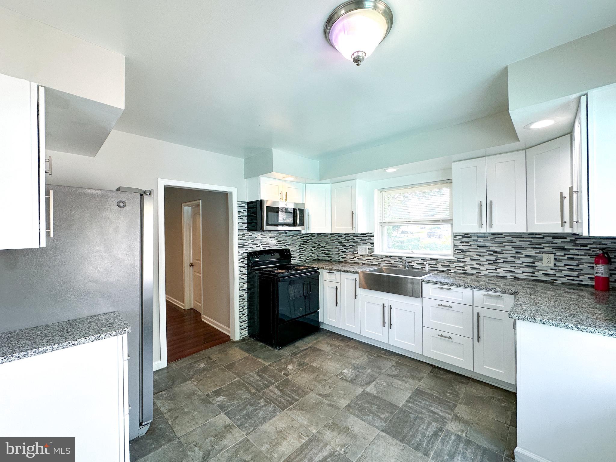 2191 Dunks Ferry Road Bensalem, PA 19020 - Photo 16 of 33 a kitchen with stainless steel appliances granite countertop a stove a sink and a refrigerator
