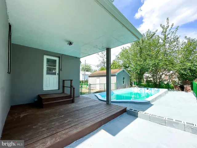a backyard of a house with barbeque oven table and chairs