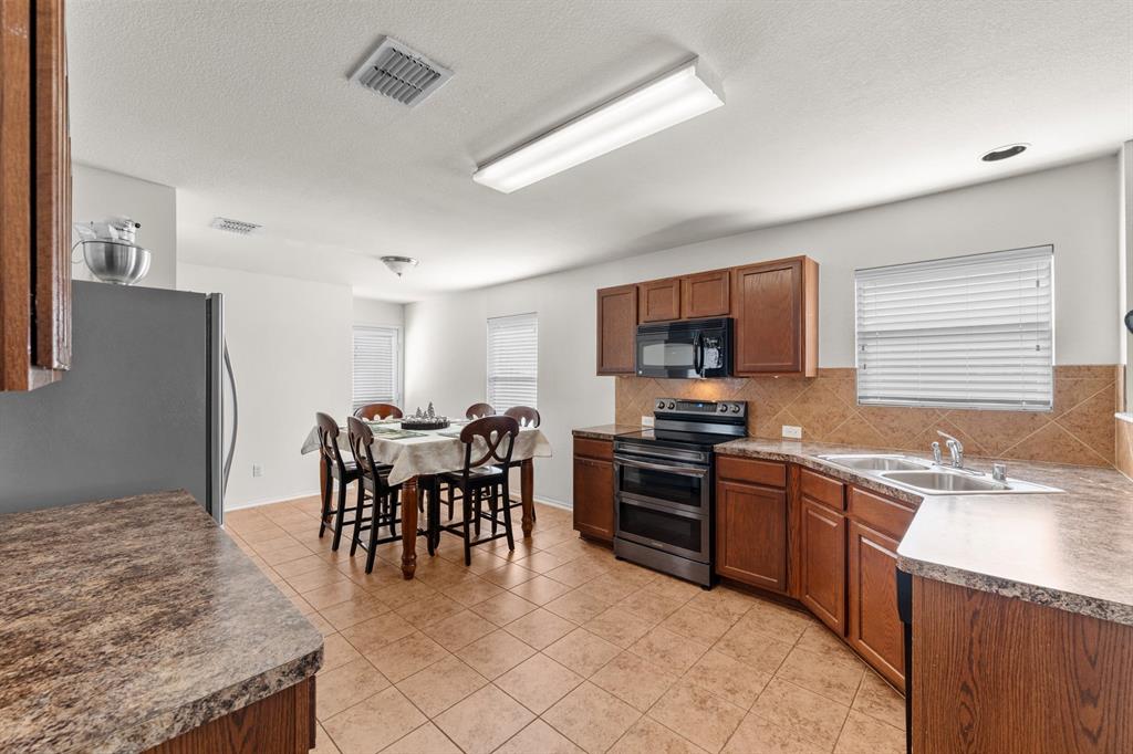 9000 Quarry Ridge Trail Fort Worth, TX 76244 - Photo 7 of 32 a dining table with chairs and kitchen view