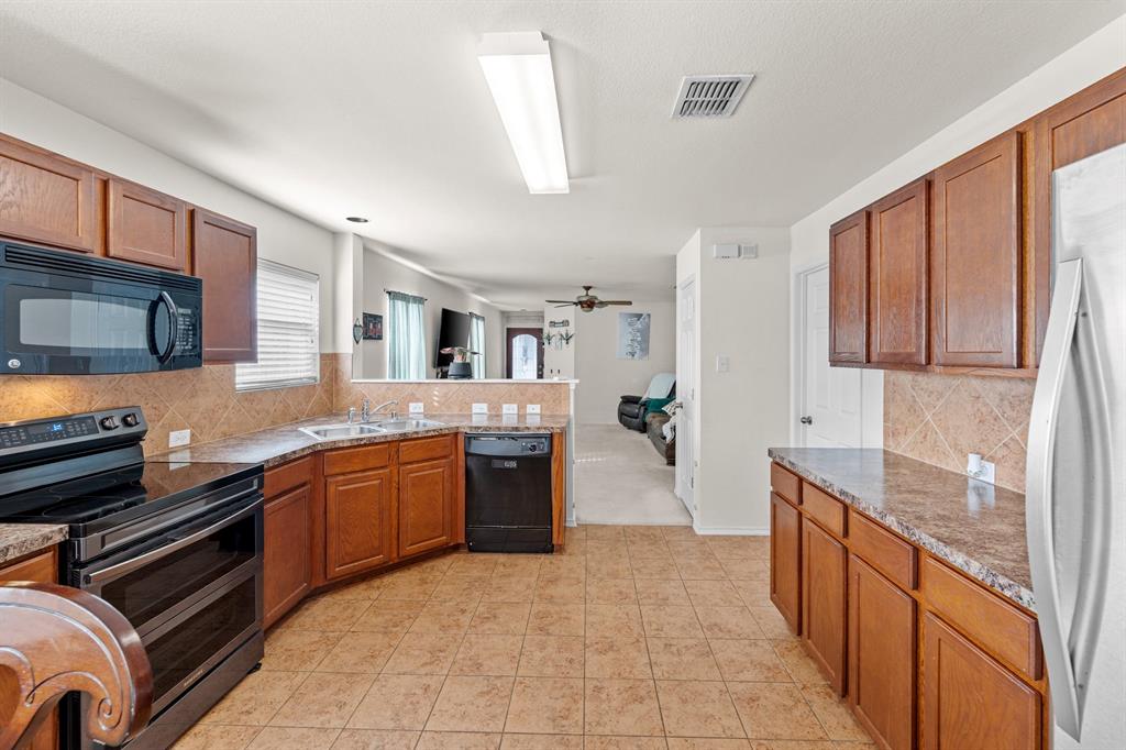 9000 Quarry Ridge Trail Fort Worth, TX 76244 - Photo 9 of 32 a large kitchen with stainless steel appliances granite countertop a stove and a sink
