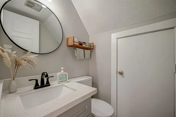 a bathroom with a sink mirror and toilet