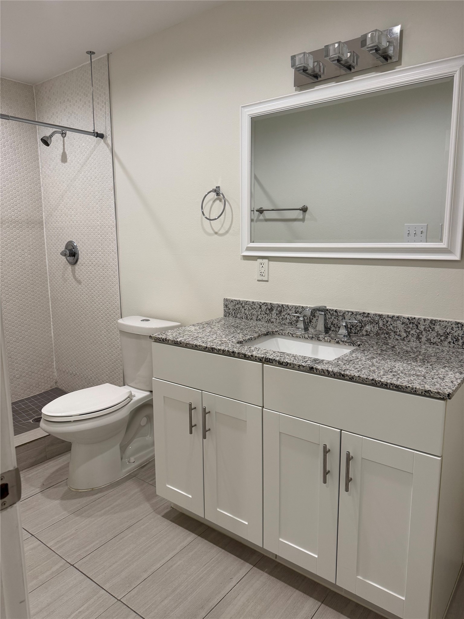 935 La Posada Drive, Unit 252 Austin, TX 78752 - Photo 16 of 20 a bathroom with a granite countertop sink a toilet and vanity