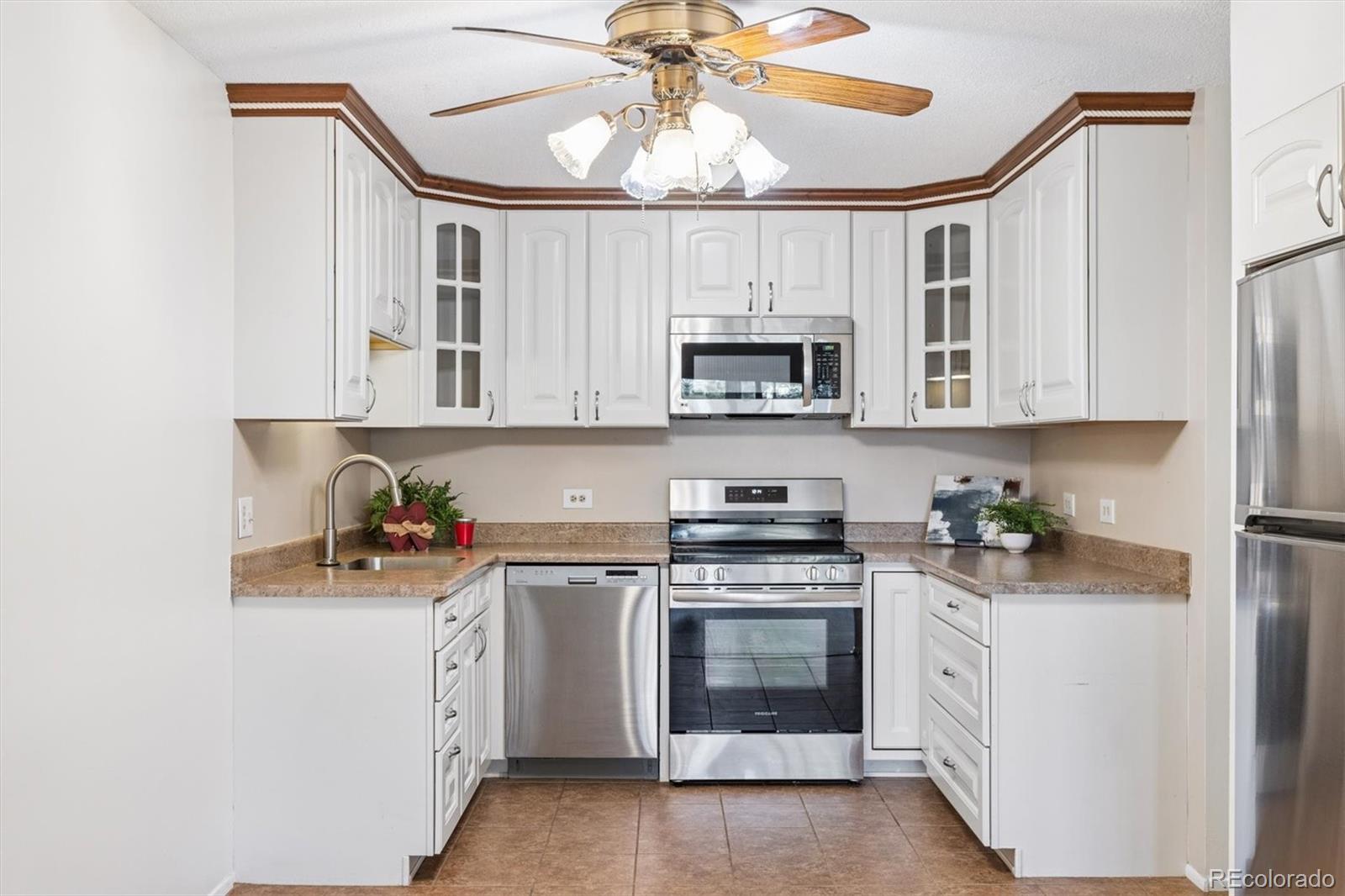 350 South Clinton Street, Unit 8B Denver, CO 80247 - Photo 2 of 50 a kitchen with stainless steel appliances a white stove cabinets and a refrigerator