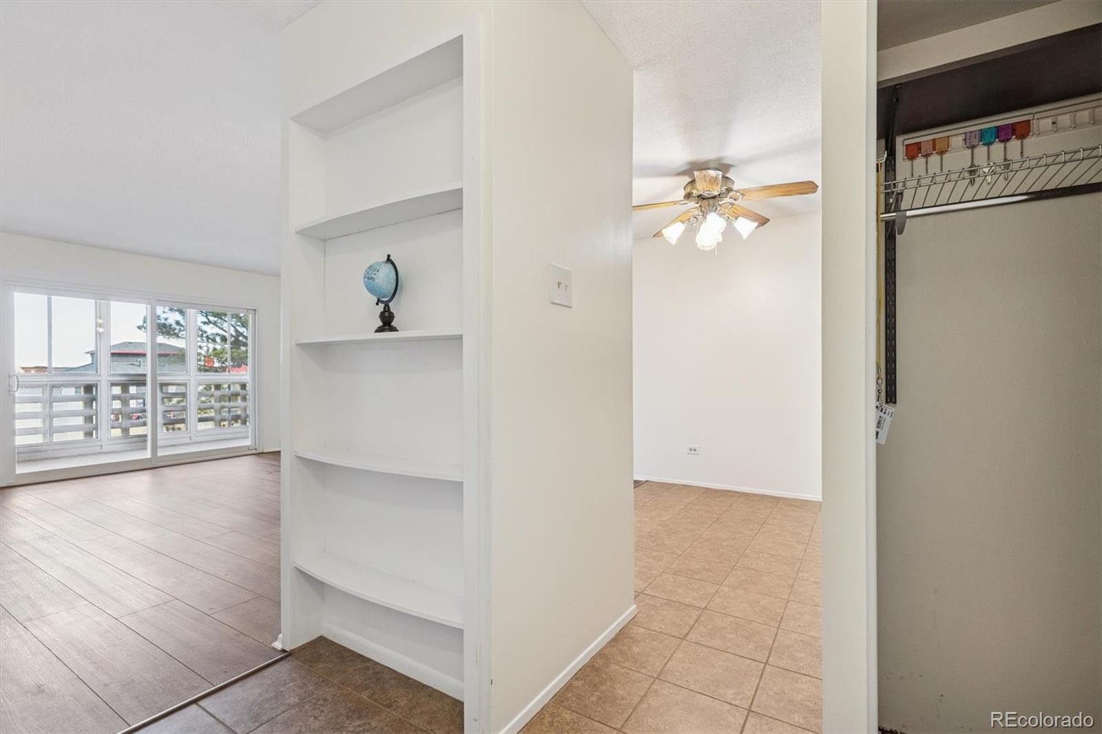 350 South Clinton Street, Unit 8B Denver, CO 80247 - Photo 4 of 50 a view of a kitchen with an empty space wooden floor and a ceiling fan