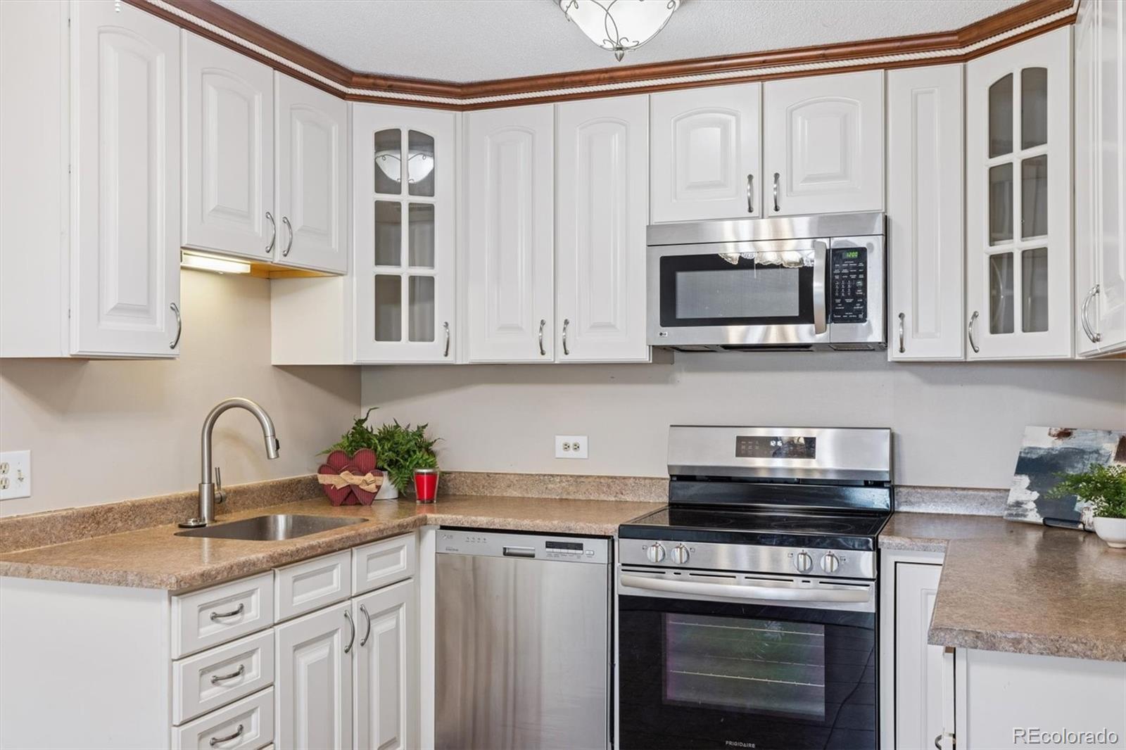 350 South Clinton Street, Unit 8B Denver, CO 80247 - Photo 8 of 50 a kitchen with stainless steel appliances granite countertop a stove a sink and a microwave