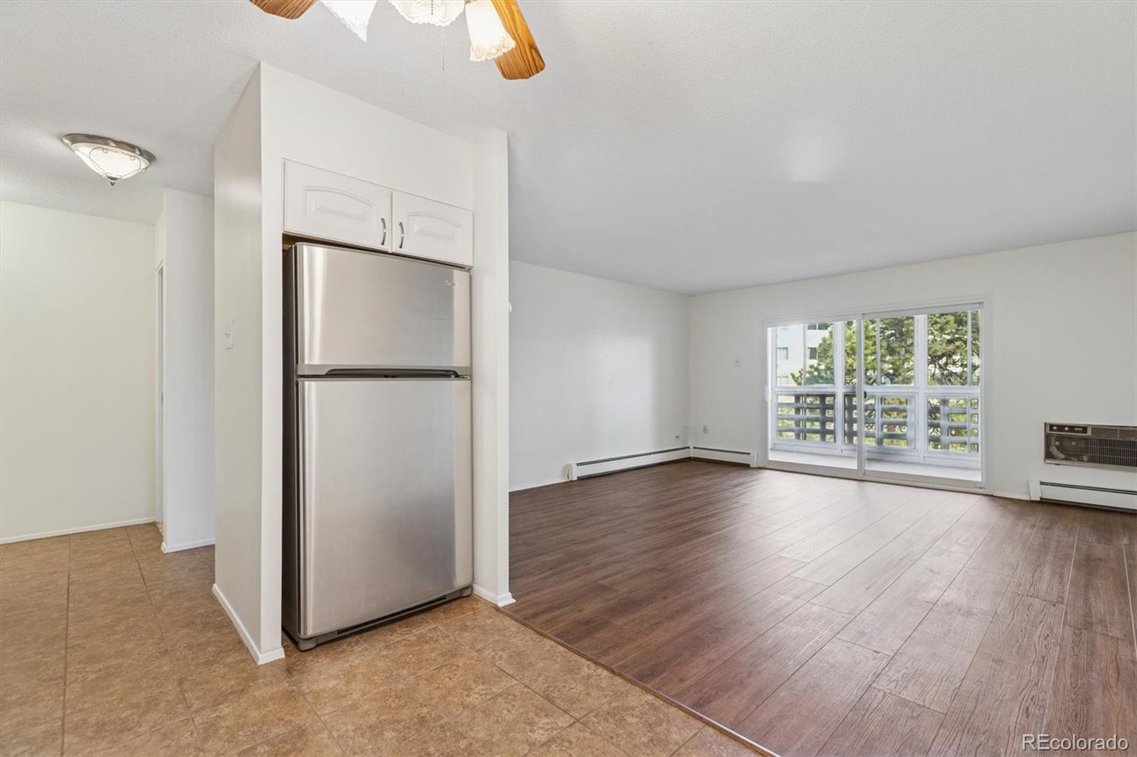 350 South Clinton Street, Unit 8B Denver, CO 80247 - Photo 9 of 50 a view of an empty room with wooden floor and a window