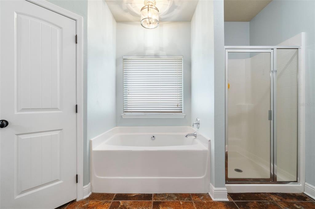 5973 Rustic Ridge Circle Milton, FL 32570 - Photo 18 of 44 a bathroom with a bathtub and a shower