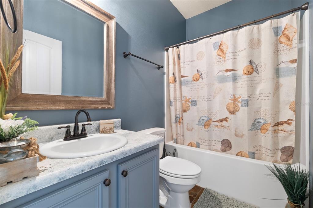 5973 Rustic Ridge Circle Milton, FL 32570 - Photo 21 of 44 a bathroom with a granite countertop sink a toilet and a bathtub