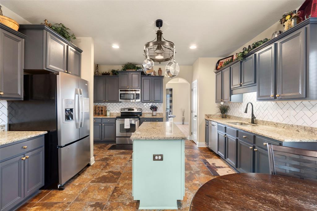 5973 Rustic Ridge Circle Milton, FL 32570 - Photo 27 of 44 a kitchen with stainless steel appliances granite countertop a sink stove and refrigerator