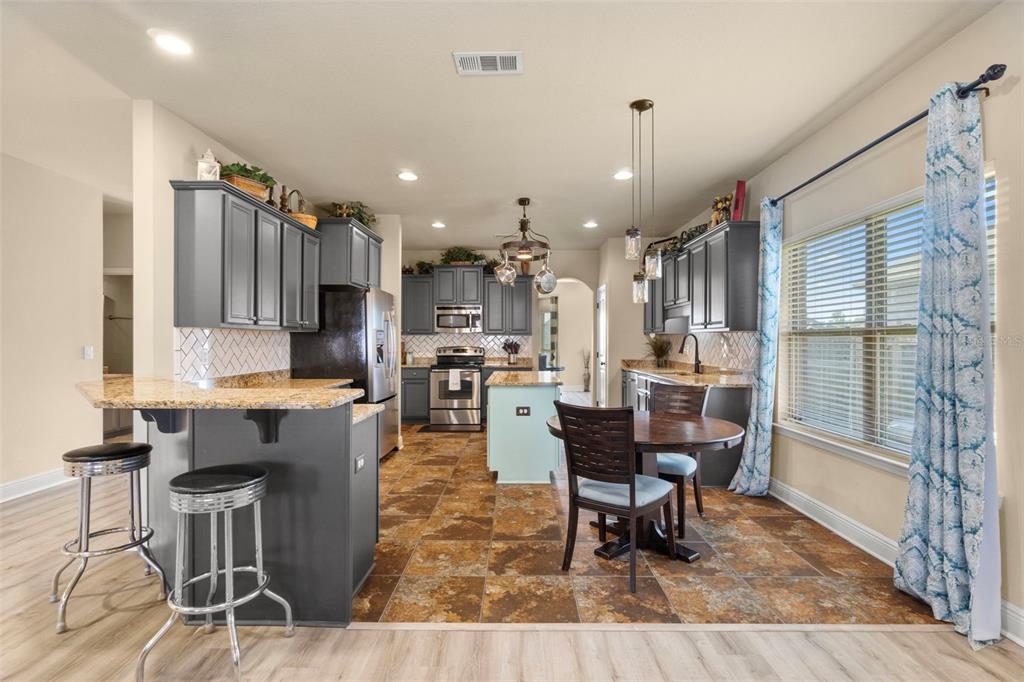 5973 Rustic Ridge Circle Milton, FL 32570 - Photo 28 of 44 a living room with stainless steel appliances kitchen island granite countertop furniture and a wooden floor