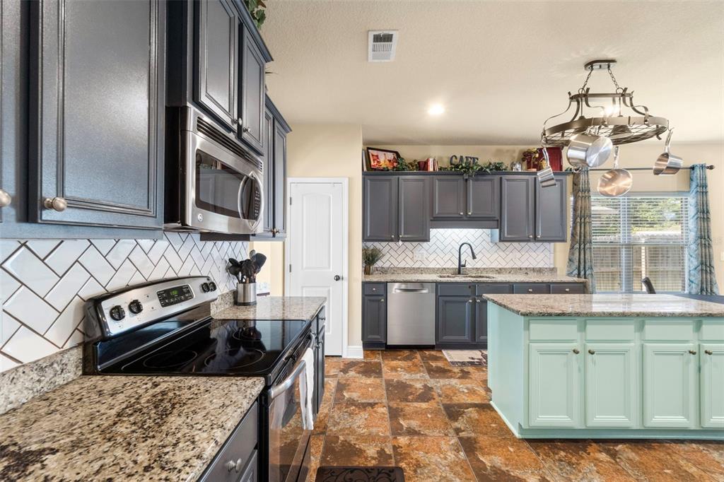 5973 Rustic Ridge Circle Milton, FL 32570 - Photo 32 of 44 a kitchen with stainless steel appliances granite countertop a sink stove and refrigerator