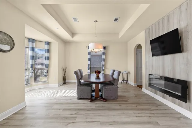 a dining room with furniture a chandelier and wooden floor