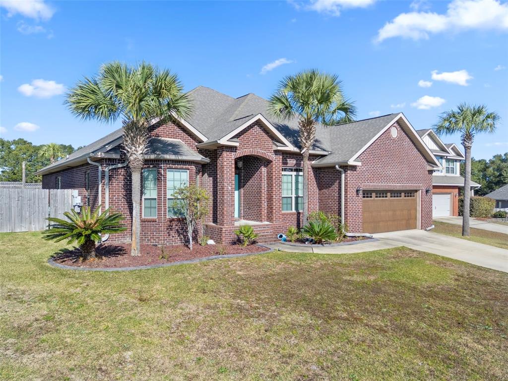 5973 Rustic Ridge Circle Milton, FL 32570 - Photo 42 of 44 a front view of a house with a garden and plants