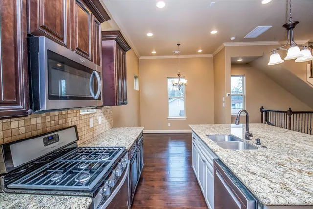 a kitchen with stainless steel appliances granite countertop a stove refrigerator sink and cabinets